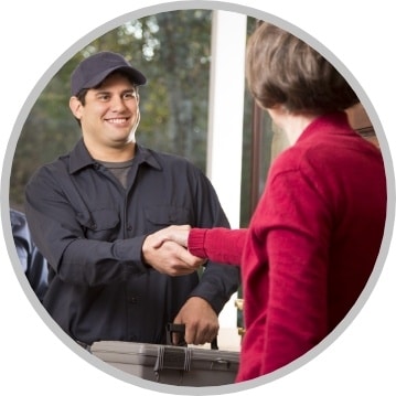 Woman greeting technician at front door and shaking hands